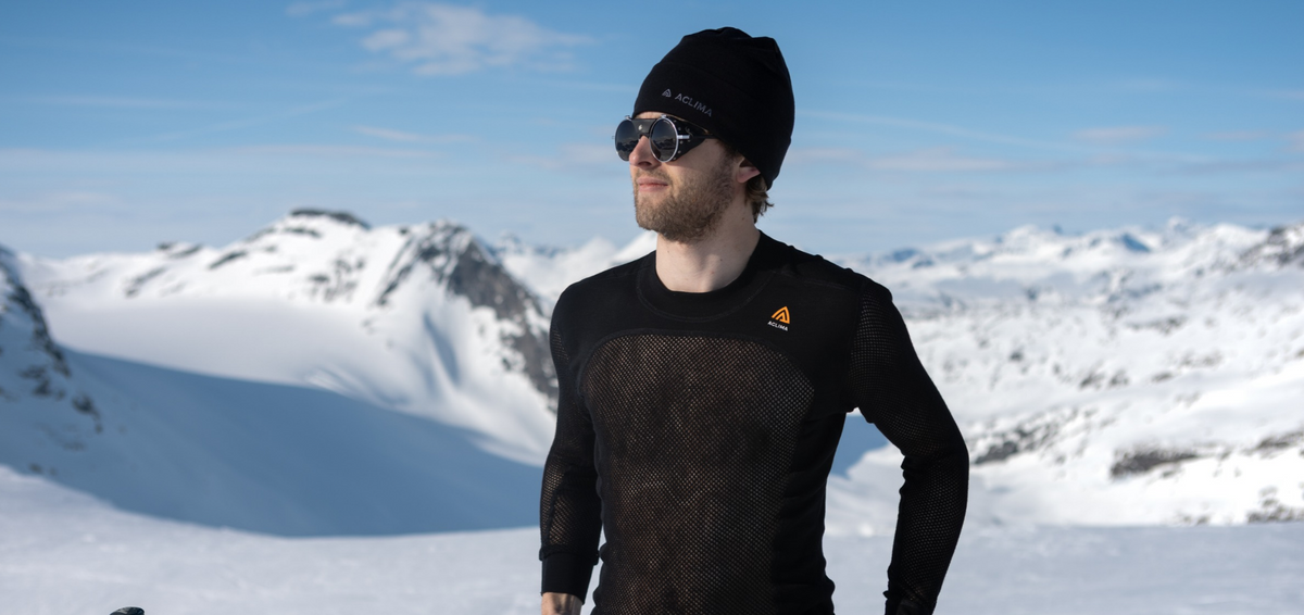 Man wearing an Aclima WoolNet mesh merino base layer top in the mountains