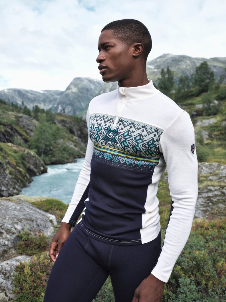 Man wearing a Dale of Norway Vail merino base layer half zip by a mountain river