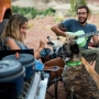Couple camping are feeding their dogs who are wearing Ruffwear's crag collar dog collar